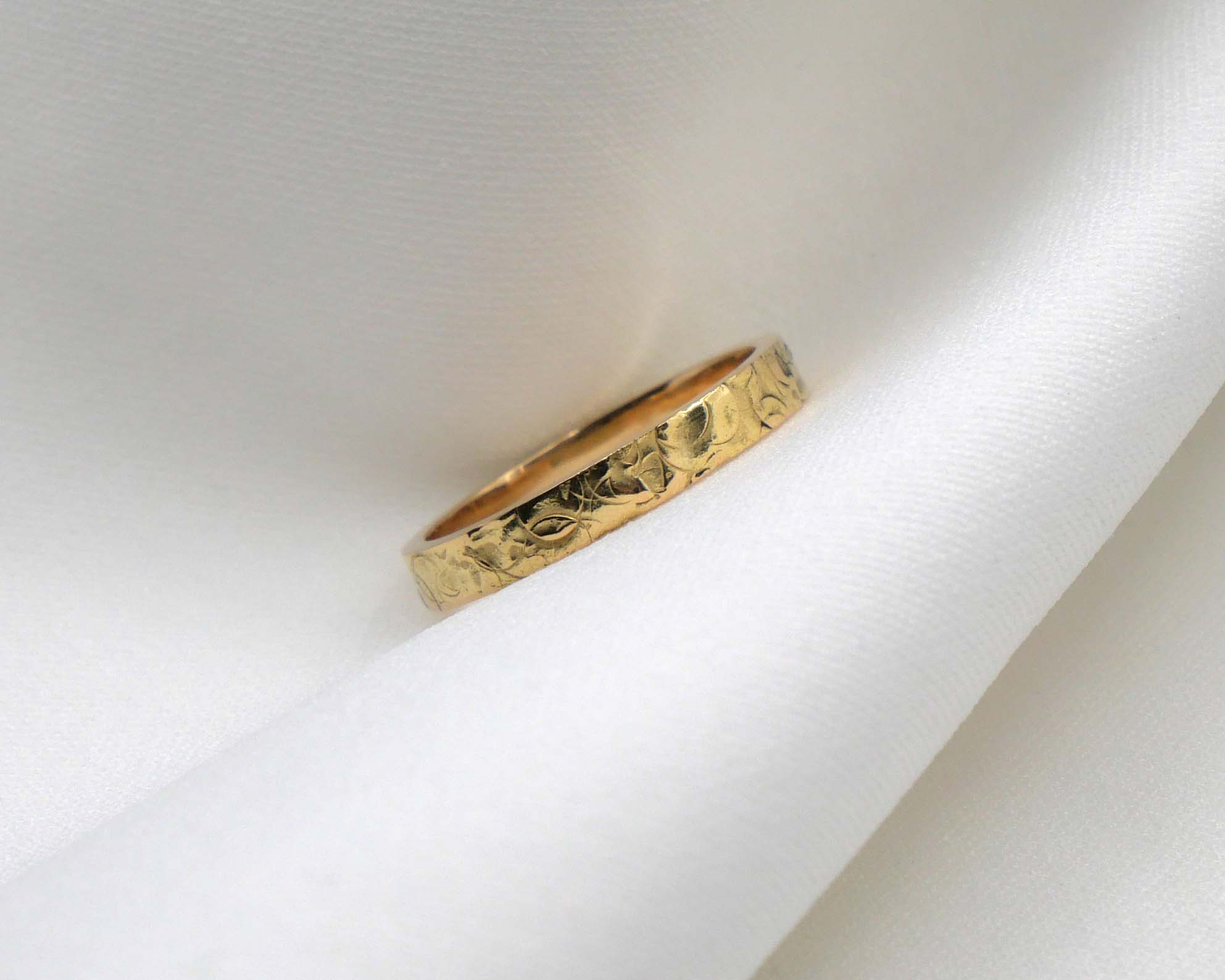 Alliance ruban en or jaune posée sur un tissu blanc